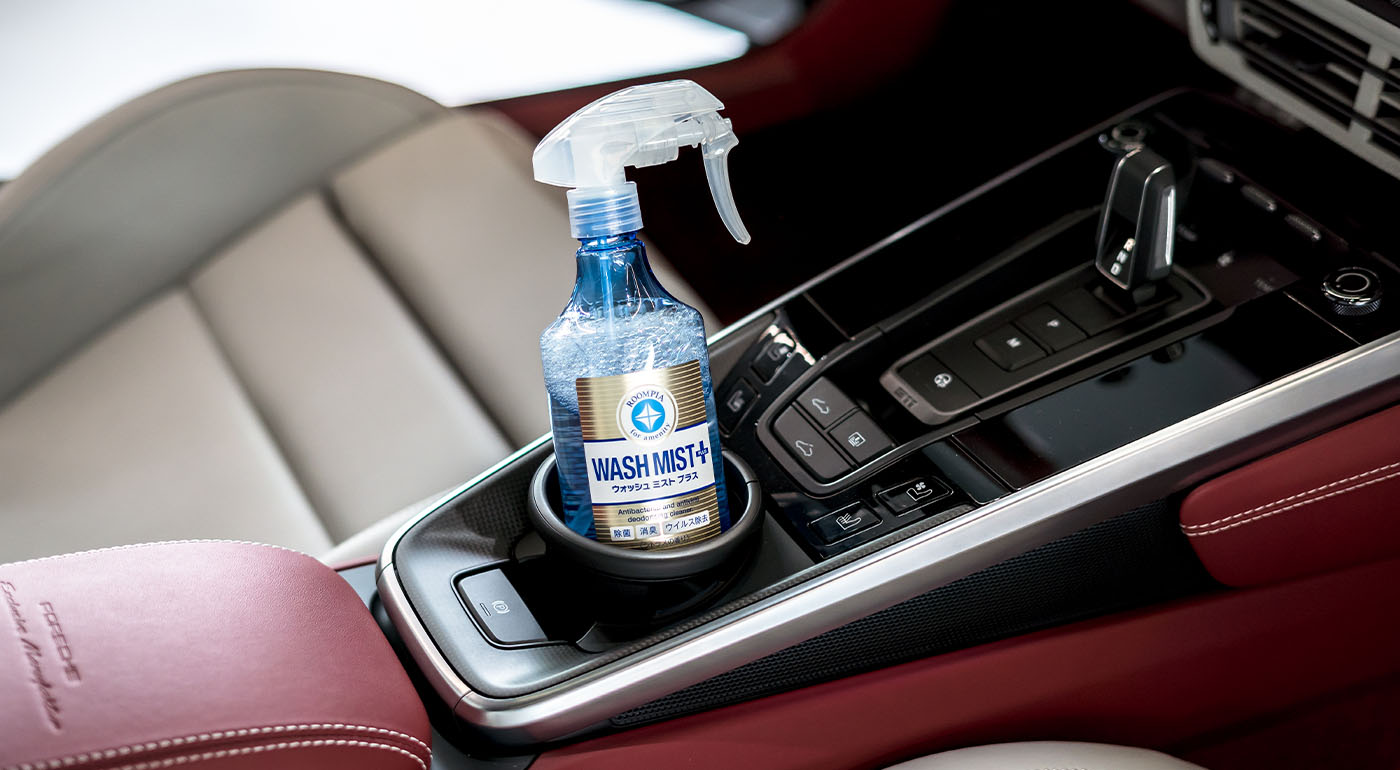 Soft99 interior car care product Wash Mist Plus in a car's cupholder.